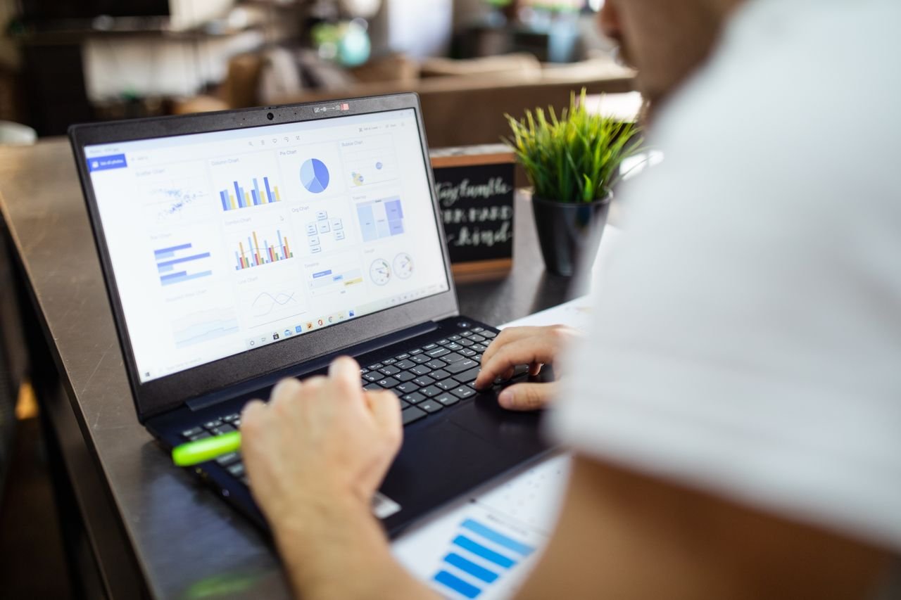 Digital Marketing Freelancer in Ahmedabad working on laptop with marketing analytics and performance charts.